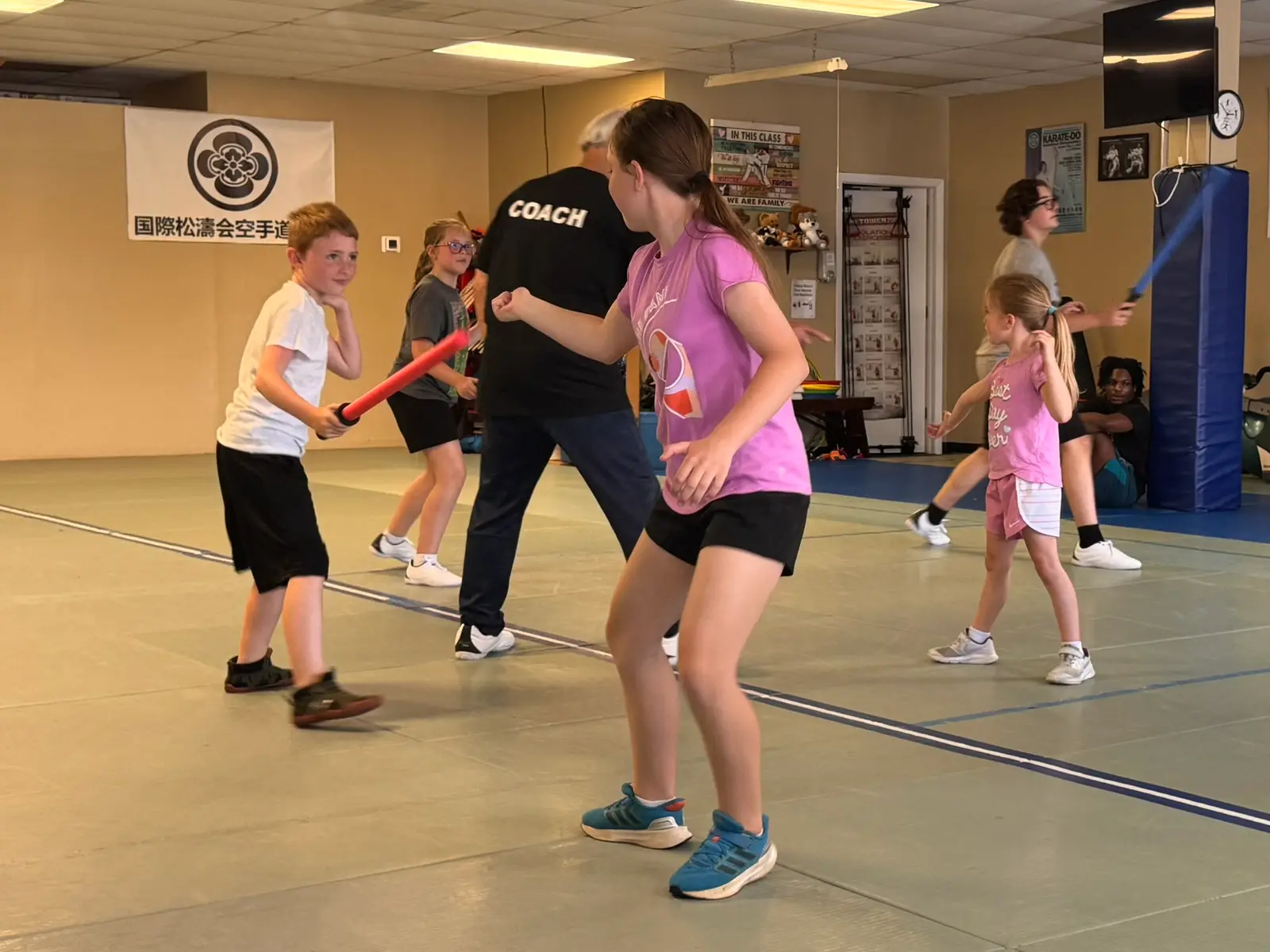 Coach working one-on-one with a beginner fencer