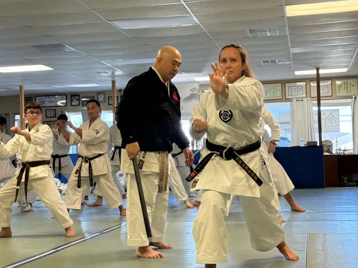 Instructor guiding an adult student through kata
