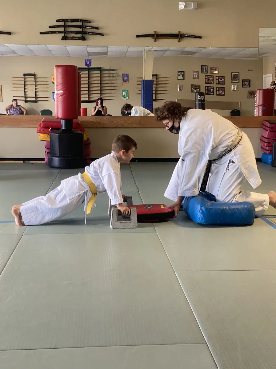 Instructor supervising a young student during conditioning